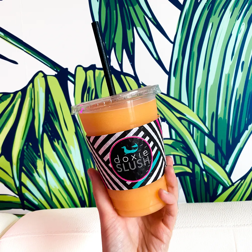 Orange slush in front of the Doxie Slush tropical wall